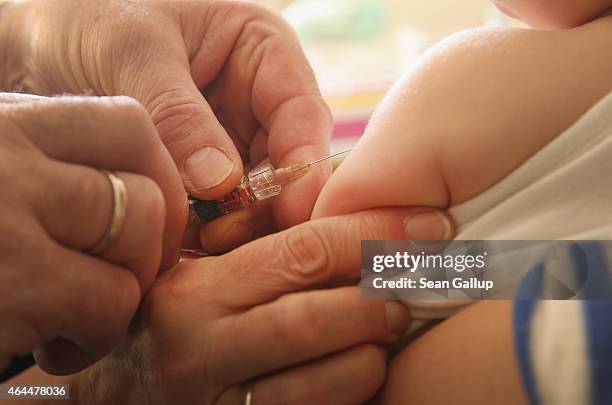 Children's doctor injects a vaccine against measles, rubella, mumps and chicken pox to an infant on February 26, 2015 in Berlin, Germany. The city of...