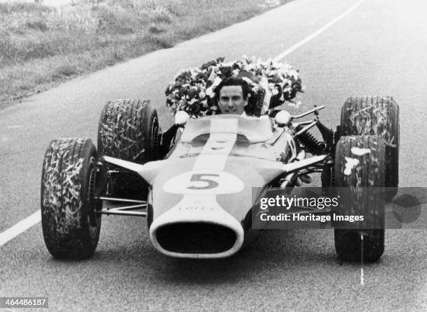 Jim Clark in a Lotus with the winner's laurel wreath. He won the Formula 1 World Championship twice, in 1963 and 1965. Clark drove exclusively for...