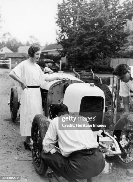 June and Woolf Barnato. June leans against the side of the car while Woolf inspects the front of it. Woolf Barnato was one of the Bentley Boys, and...