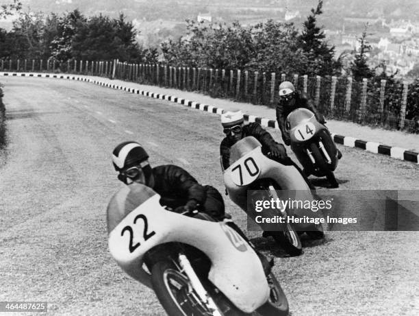 Isle of Man Senior TT Race, 1958. Arthur Wheeler, on an AJS is closely pursued into a corner by two Nortons. Wheeler finished 35th in the race, which...