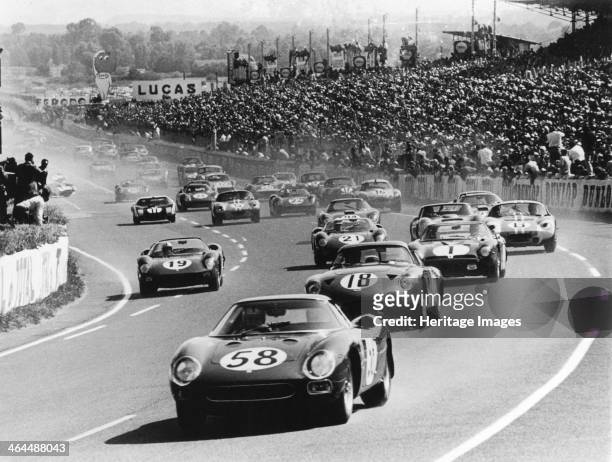 Start of the Le Mans 24 Hours, France, 1964. A large crowd watches as David Piper's Ferrari lead's Mike Salmon's Aston Martin into the first bend....