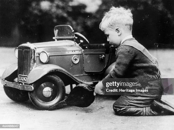Michael Ware repairing a pedal car. Michael Ware became the director of the National Motor Museum Trust.