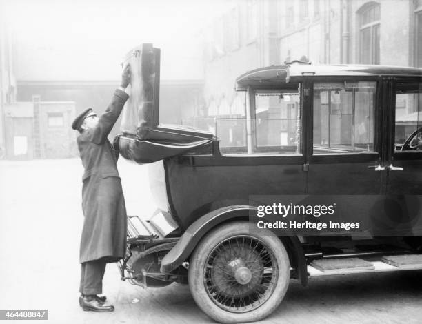 Chauffeur with a partly convertible Daimler.