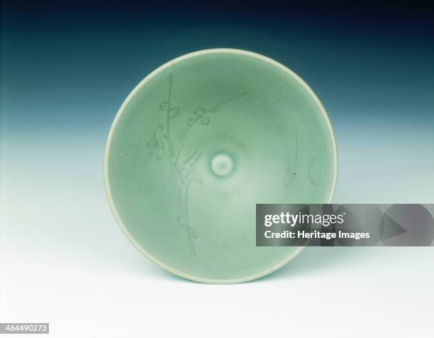 Celadon bowl with prunus spray under a crescent moon, late Southern Song dynasty, China, 1200-1279. A small tea bowl of open form with carved design...