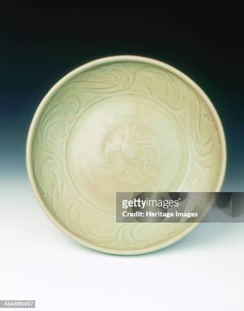 Celadon dish with moulded tree and incised scrolls, Yuan-Ming dynasty, China, 14th century. A Zhejiang celadon deep dish with an unusual rim. The...