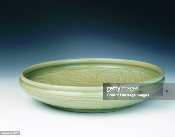 Celadon dish with moulded tree and incised scrolls, Yuan-Ming dynasty, China, 14th century. A Zhejiang celadon deep dish with an unusual rim. The...