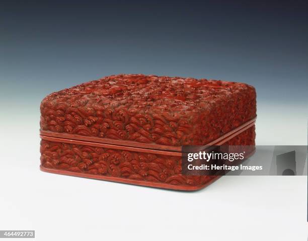 Carved red lacquer covered box, Qing dynasty, China, mid-late 18th century. A square red lacquer box carved with swirling waves and four prancing...