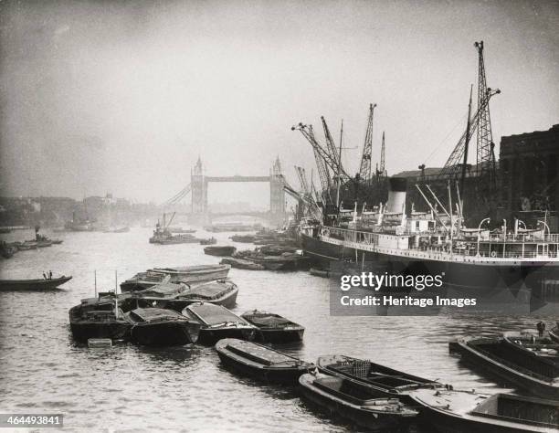 View of the busy Thames looking towards Tower Bridge, London, c1920. The construction of Tower Bridge was begun in 1881 to designs by Sir Horace...