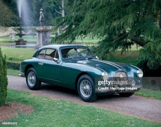 Aston Martin DB2 saloon car photographed in a stately garden.