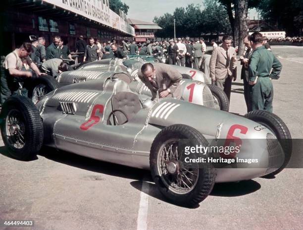 Auto Unions, . A line of them being worked on by mechanics in the pits. In 1928 the Auto Union racing team consisted of such great drivers as Tazio...