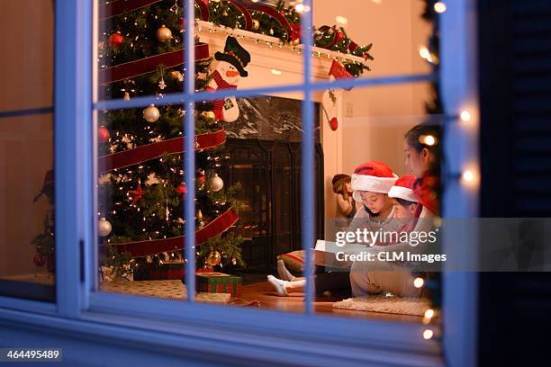 mother and kids on christmas - christmas window stock pictures, royalty-free photos & images