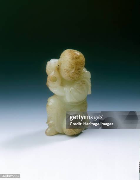 Yellowish jade kneeling tribute bearer, Tang or Liao dynasty, China, 8th-11th century. A jade figure of a tribute bearer kneeling on one knee the...