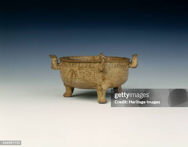 Proto-Yue tripod pot, Late Warring States, China, c3rd-2nd century BC. Ding with serpent-shaped handles. The grey body is covered with an olive green...