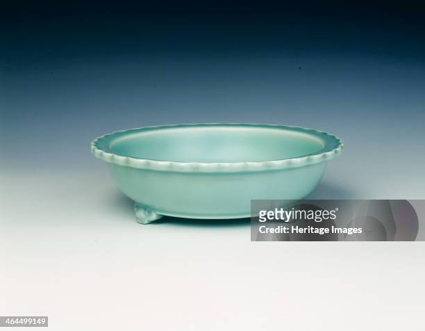 Celadon tripod basin, Qing dynasty, Yongzheng period, China, 1723-1735. Bright bluish-green celadon glazed tripod basin with everted rim with lipped...