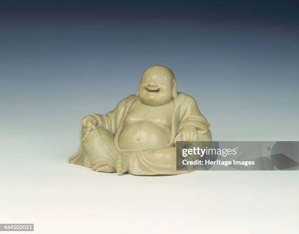 Soapstone laughing Buddha, Qing dynasty, China, late 17th-18th century. A light yellowish-green soapstone figure of a reclining laughing Buddha...