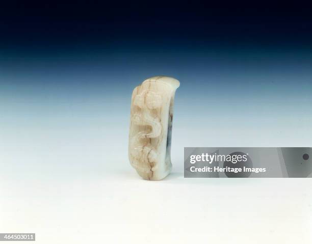 Jade fitting with tortoise belching clouds, Yuan or early Ming dynasty, China, 14th-15th century. A pale grey and brown-flecked jade belt or dagger...
