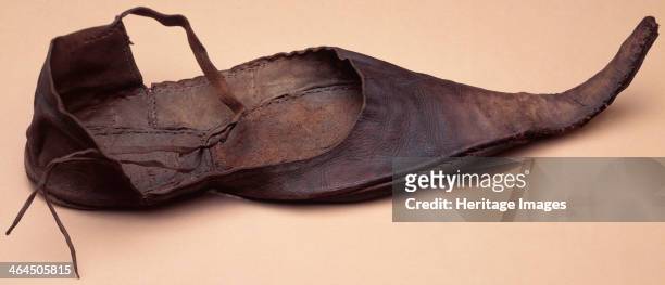 Leather adult's shoe, medieval. This pointed shoe has straps which were probably fastened around the wearer's ankle.