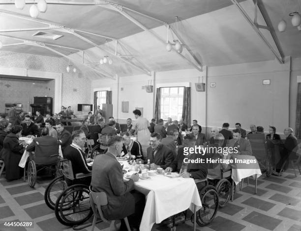 Dining hall of the CISWO paraplegic centre, Pontefract, West Yorkshire, 1960. Residents and visitors take time out from retaining for new skills to...