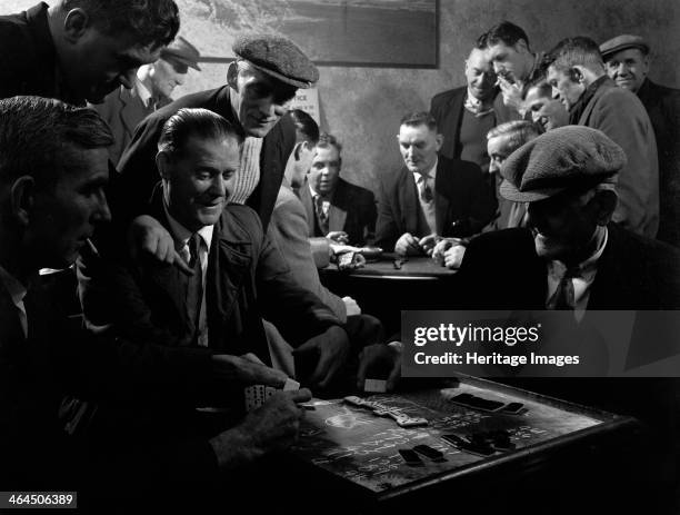 Miners socialising at the miners' welfare club, Horden Colliery, Sunderland, Tyne and Wear, 1964. Miners old and young playing dominoes and cards in...