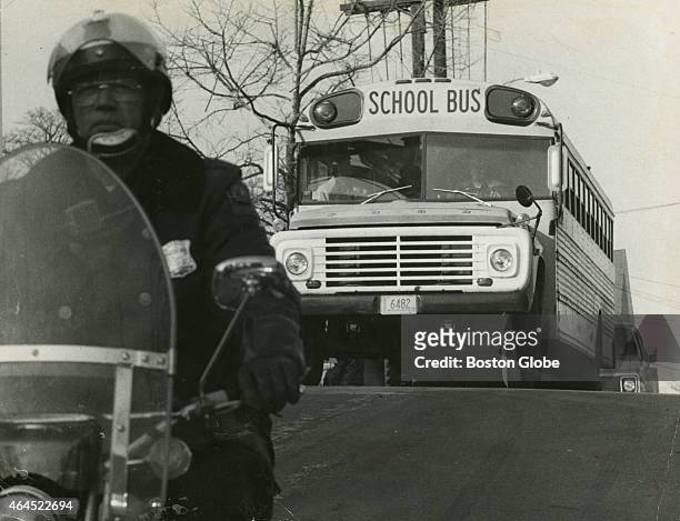 Single school bus carrying black students follows a police escort down G Street in South Boston on an afternoon in March 1975. An initiative to...