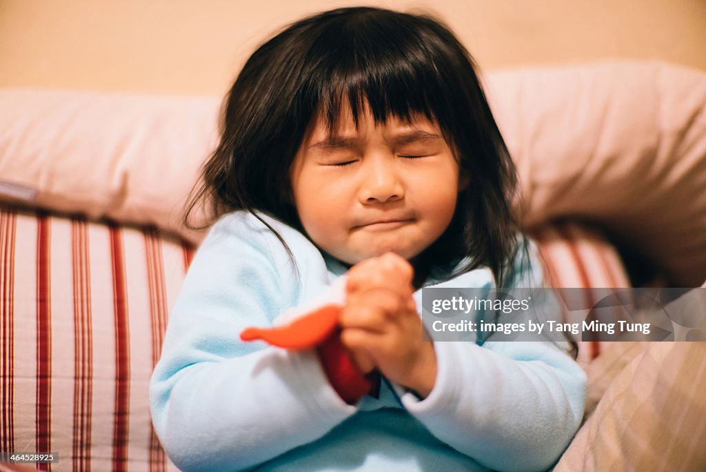 Toddler girl making wish / praying sincerely