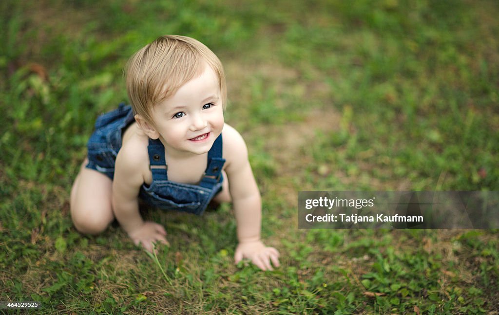 Happy, smiling Baby crawling around in Grass