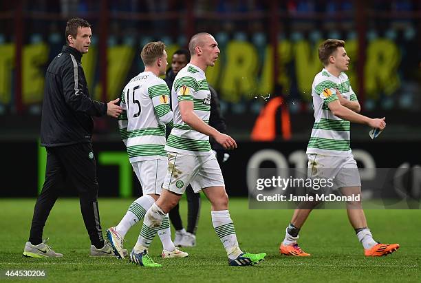 Dejected Scott Brown of Celtic and team mates leave the field after defeat in the UEFA Europa League Round of 32 match between FC Internazionale...