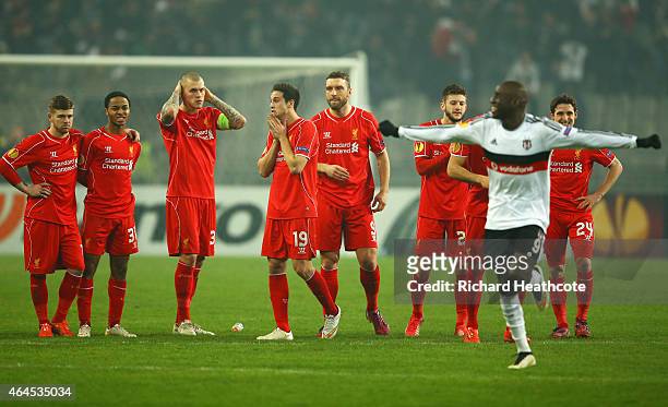 Liverpool players look dejected as Demba Ba of Besiktas celebrates as Dejan Lovren of Liverpool misses the decisive kick in the penalty shoot out...