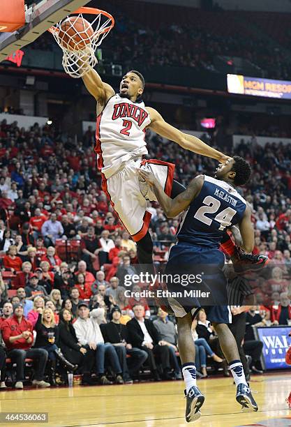 Khem Birch of the UNLV Rebels dunks over JoJo McGlaston of the Utah State Aggies during their game at the Thomas & Mack Center on January 22, 2014 in...