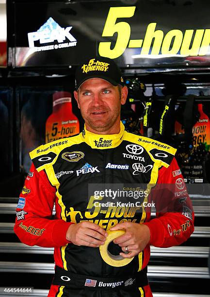 Clint Bowyer, driver of the 5-Hour Energy Toyota, stands in the garage during a testing session at Atlanta Motor Speedway on February 26, 2015 in...