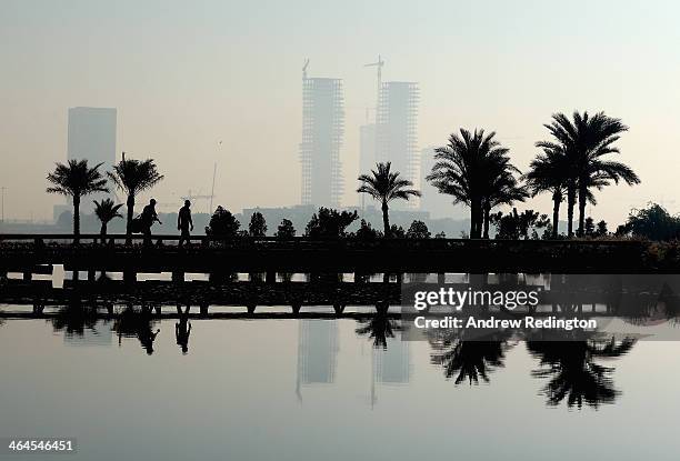 Peter Uihlein and his caddie cross the bridge on the 15th hole during the second round of the Commercial Bank Qatar Masters at Doha Golf Club on...