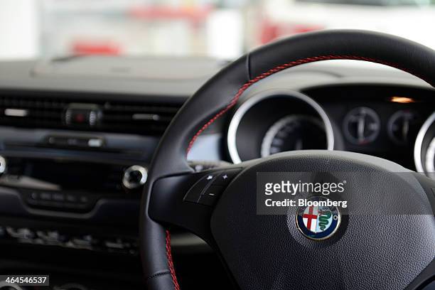 The Fiat SpA Alfa Romeo logo is displayed on the steering wheel of a Giulietta automobile inside a GST Co. Showroom in Tokyo, Japan, on Wednesday,...