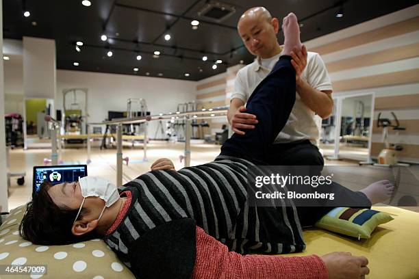 Mieko Kawakami, who suffers from gait disorder due to partial paralysis, left, receives treatment from physiotherapist Koji Ono before being fitted...