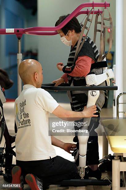 Mieko Kawakami, who suffers from gait disorder due to partial paralysis, right, walks with an assistive walking device after being fitted with...