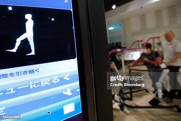 The motion status of Mieko Kawakami, who suffers from gait disorder due to partial paralysis, second right, is displayed on a monitor as she uses...