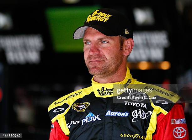 Clint Bowyer, driver of the 5-Hour Energy Toyota, stands in the garage during a testing session at Atlanta Motor Speedway on February 26, 2015 in...