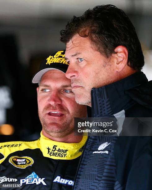 Clint Bowyer, driver of the 5-Hour Energy Toyota, converses with Michael Waltrip during a testing session at Atlanta Motor Speedway on February 26,...