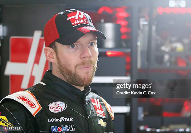 Regan Smith, driver of the Haas Automation Chevrolet, stands in the garage during a testing session at Atlanta Motor Speedway on February 26, 2015 in...