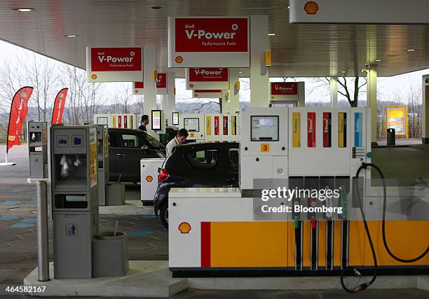 Customers refuel automobiles from gas pumps on the forecourt of a petrol station operated by Royal Dutch Shell Plc in Alkmaar, Netherlands, on...