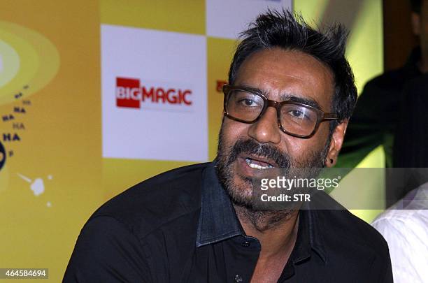 Indian Bollywood film actor, Ajay Devgn, as a brand ambassador for Hajmola Chatpata No.1, poses during a promotional event in Mumbai on February 26,...