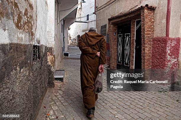 Man wearing the traditional djellaba and walking by the streets.
