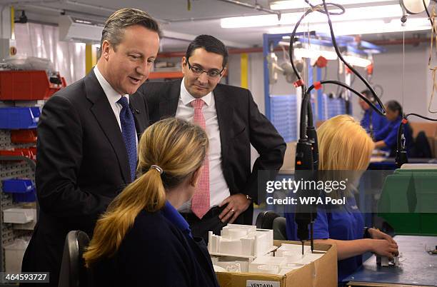 Prime Minister David Cameron talks to a member of staff during his visit to the headquarters of ventilation manufacturer, Vent-Axia with Chief...