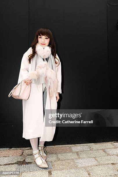 Carrie Kwok stylist and make up artist from Hong kong wearing a pale pink coat by Injury, accesorising with a scarf by Hidying featuring bearded...