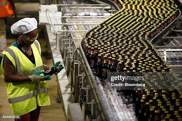 Worker inspects a bottle of Meta beer on the bottling line at the Meta Abo brewery, operated by Diageo Plc in Sebeta, Ethiopia, on Wednesday, Feb....