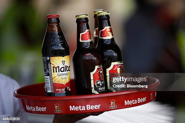 Bottles of Guinness Malt and Meta beer, stand on a waiter's tray at the Meta Abo brewery, operated by Diageo Plc in Sebeta, Ethiopia, on Wednesday,...