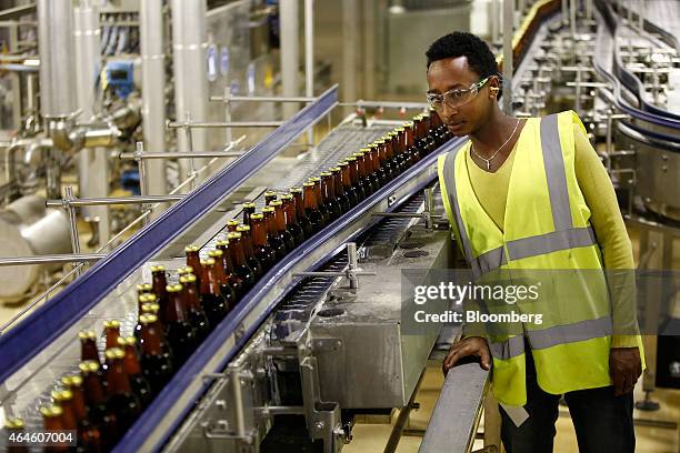 Worker inspects bottles of Meta beer as they move along the production line at the Meta Abo brewery, operated by Diageo Plc in Sebeta, Ethiopia, on...