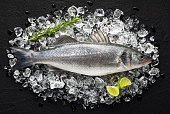 Fresh fish on ice on a black stone table