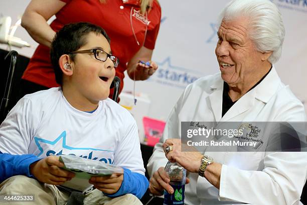 Starkey Founder and CEO William Austin assists a patient in getting tested and fitted for hearing aids at the Starkey Hearing Foundation Mission...