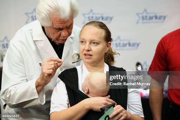 Starkey Founder and CEO William Austin assists patient Irit Streett with fitting her new hearing aids at the Starkey Hearing Foundation Mission...