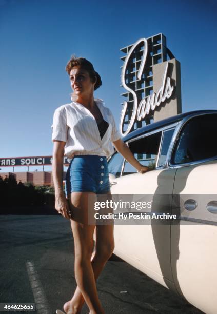 Model poses next to a 1954 Buick Roadmaster outside the Sands Hotel in 1955 in Las Vegas, Nevada.